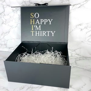 Hochwertige schwarze Geschenkbox zum 30. Geburtstag für Männer, mit weißem Schriftzug 'So Happy I'm Thirty' auf dem Deckel.