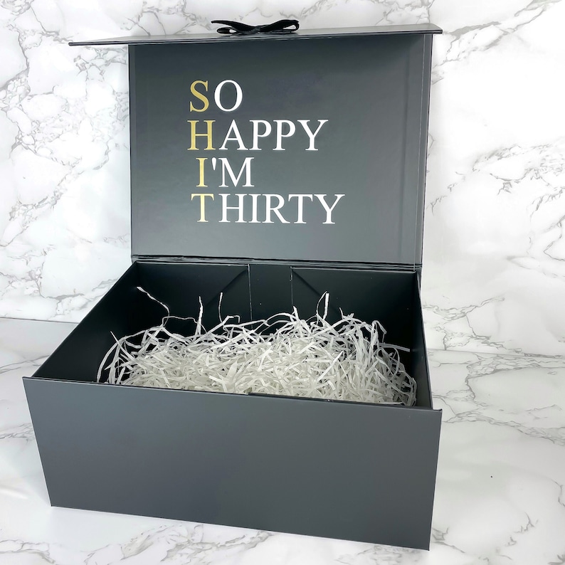 Hochwertige schwarze Geschenkbox zum 30. Geburtstag für Männer, mit weißem Schriftzug 'So Happy I'm Thirty' auf dem Deckel.