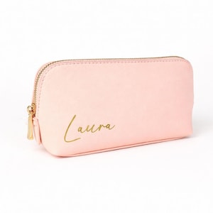 Personalisierte Kosmetiktasche in Rosa mit Name Laura in Goldschrift auf hellem, neutralem Hintergrund