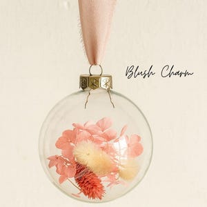 Personalisierte Weihnachtskugel aus Glas mit goldenen Kranz und rosa Chiffon-Aufhänger, gefüllt mit rosa Trockenblumen: Lagurus, Phalaris und Hortensien, Variante ‚Blush Charm‘.