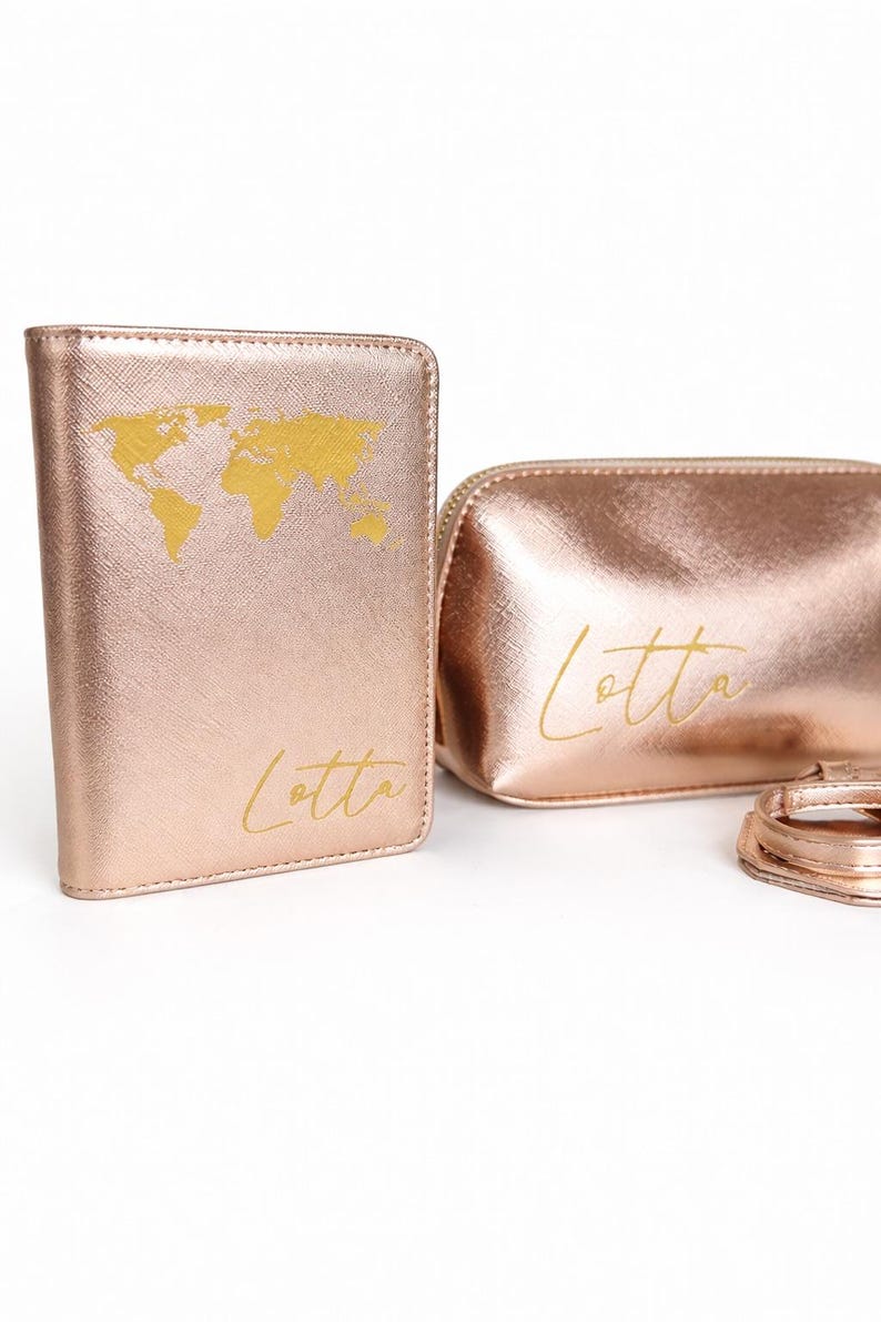 Personalisierte Reisepasshülle und Kosmetiktasche in Roségold mit goldener Weltkarte und Name Lotta auf hellem, neutralem Hintergrund