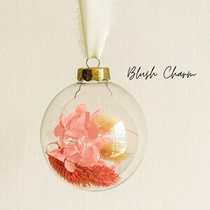 Personalisierte Weihnachtskugel aus Glas mit goldenen Kranz und weißen Chiffon-Aufhänger, gefüllt mit rosa Trockenblumen: Lagurus, Phalaris und Hortensien, Variante ‚Blush Charm‘.