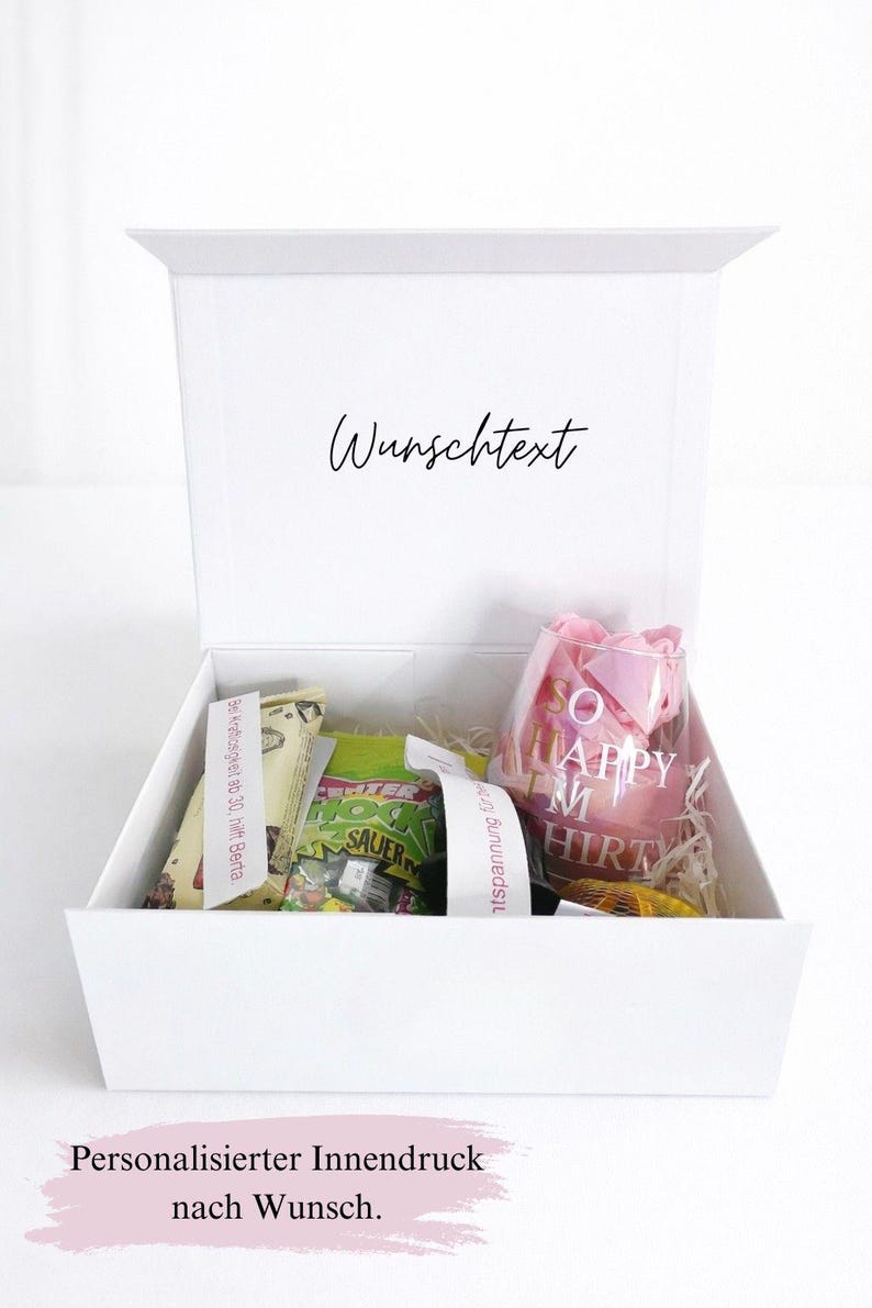 Offene weiße Geschenkbox mit Beispiel-Füllung und personalisiertem Innendruck ‚Wunschtext‘ im Deckel