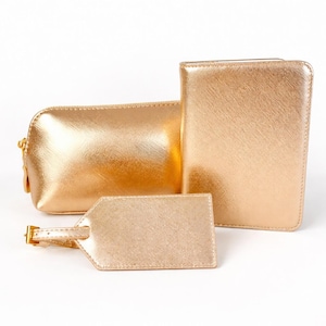 Elegantes Reiseset in Roségold mit Kosmetiktasche, Reisepasshülle und Kofferanhänger auf hellem, neutralem Hintergrund