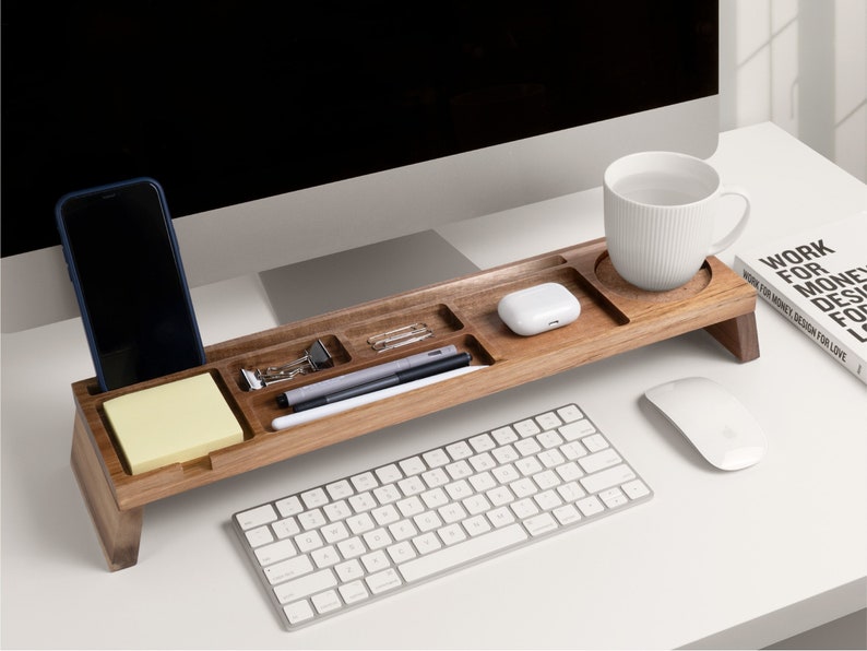 A wooden desk organizer on a desk with items on it