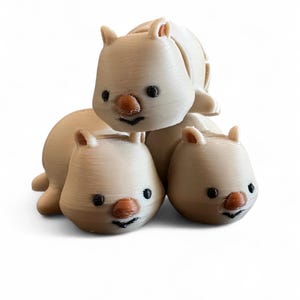 May include: Three small, white, 3D printed animal figurines with black eyes and orange noses. The figurines are stacked on top of each other.
