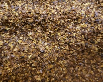 May include: Close-up of a pile of brown and yellow ground spices.
