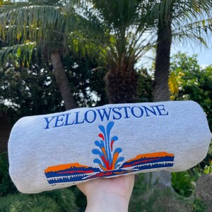 May include: Gray sweatshirt with a colorful graphic of a geyser and the text "Yellowstone National Park" printed on the front.