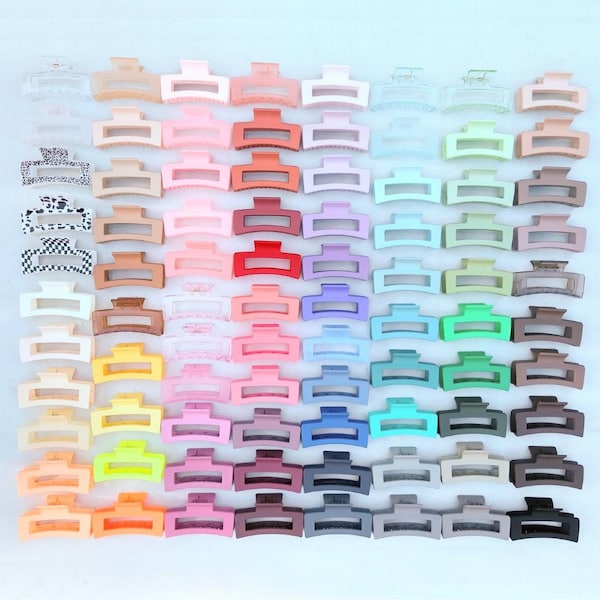 May include: A large collection of rectangular plastic hair claw clips arranged in a grid. The clips feature a variety of solid colours including pastels, bright tones, and neutrals, along with some patterned designs like leopard print and checkerboard.