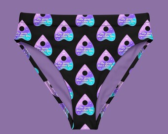 May include: Black bikini bottoms with a repeating pattern of purple and blue Ouija board planchette shapes with the text "The Spirits Don't Like You" on each planchette.