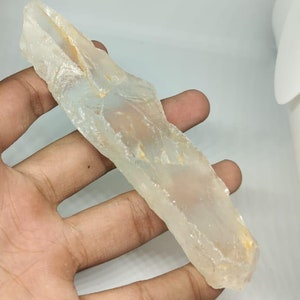 May include: A translucent white crystal with a slightly yellow hue. The crystal is rough and has a natural, irregular shape.