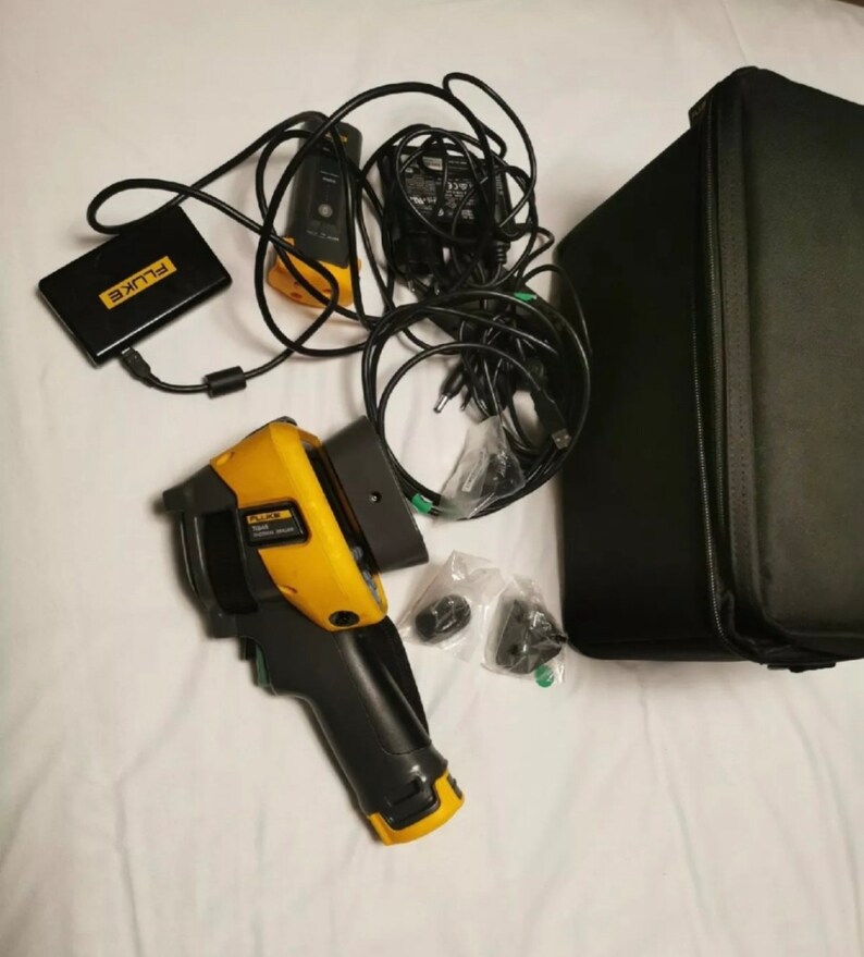 May include: A yellow and black Fluke thermal imaging camera with a black carrying case, a black power adapter, and a black battery pack. The camera has a black handle and a yellow trigger.