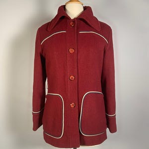 Puede incluir: Una taza de cerámica blanca con un asa negra y el texto "But First, Coffee" en negro y negrita. La taza está sobre una superficie blanca.