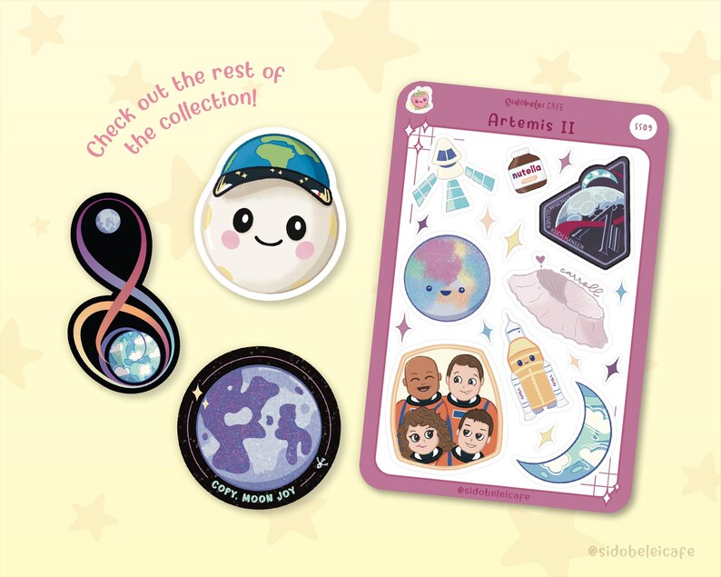 May include: A collection of stickers and sticker sheets with a space theme. The stickers include a smiling moon wearing a hat with the Earth on it, a planet, and a sticker sheet with various space-themed illustrations. Text includes "Artemis II".