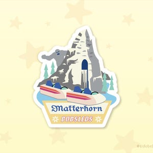 May include: A sticker featuring a stylized illustration of the Matterhorn Bobsleds ride. The design includes a mountain, bobsleds, trees, and the text "Matterhorn Bobsleds". The color palette includes shades of gray, blue, pink, and white.
