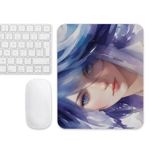 Op de afbeelding: Een rechthoekige muismat met een aquarel illustratie van een persoon met blauw haar en blauwe ogen. Een wit toetsenbord en muis bevinden zich links van de muismat.