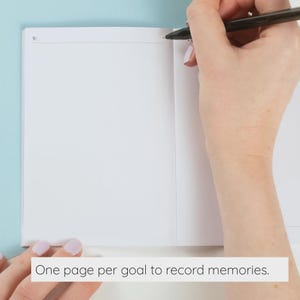 May include: An open white notebook with a black pen positioned on the top right corner of the page. The page features a thin horizontal line at the top with the number 9 printed on the left side. The notebook has blank white pages for writing.
