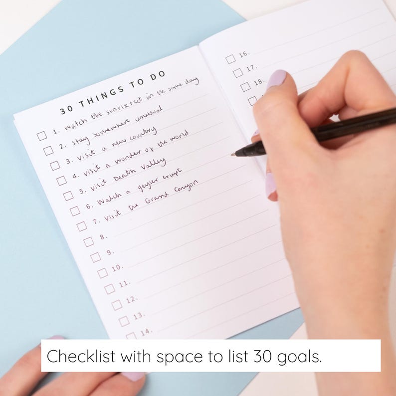 May include: An open notebook with a white page featuring a printed checklist titled 30 THINGS TO DO. The list contains numbered lines from 1 to 30 with checkboxes. Handwritten text fills the first seven lines of the list in black ink.