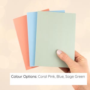 May include: Three rectangular cards in solid colors, arranged in a fan shape. The colors are coral pink, light blue, and sage green. The text at the bottom of the image reads: Colour Options: Coral Pink, Blue, Sage Green.