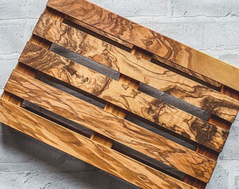 Op de afbeelding: Een houten pallet met een natuurlijk houtnerfpatroon. De pallet is gemaakt van verschillende horizontale houten latten die bij elkaar worden gehouden door kleinere verticale stukken. Het hout heeft een warme, bruine tint met donkerdere, wervelende nerfdetails.
