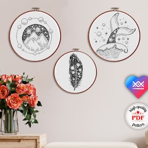 Puede incluir: Tres patrones de bordado en blanco y negro en aros circulares. Los patrones son una cordillera con estrellas, una pluma con puntos y una cola de ballena con burbujas.
