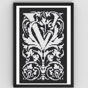May include: Black and white framed artwork featuring a symmetrical design. The artwork has a black background with a white, ornate floral pattern. The design includes a central 'V' shape and decorative flourishes, creating a classic, elegant aesthetic.