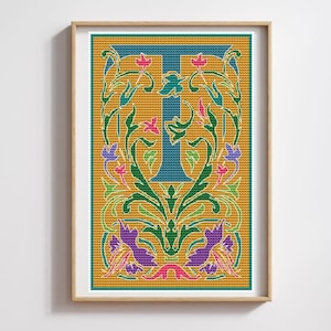 May include: A framed cross-stitch design featuring the letter 'T' in a blue color, surrounded by green, yellow, pink, and purple floral patterns on a yellow background.
