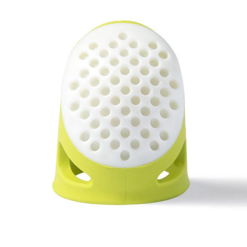 May include: A green and white finger thimble with a perforated top and two holes on the sides.