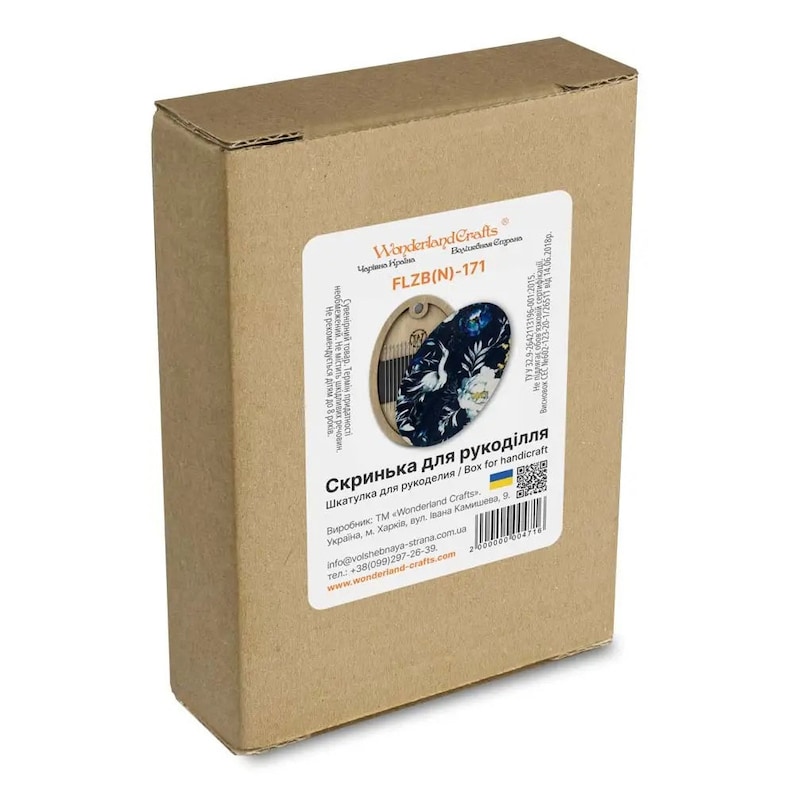 May include: A brown cardboard box with a white label. The label has a product image of a wooden box with a floral design. The text on the label reads "Wonderland Crafts", "FLZB(N)-171", "Скринька для рукоділля", "Шкатулка для рукоделия / Box for handicraft", "Виробник: ТМ "Wonderland Crafts", "Україна, м. Харків, вул. Івана Камишева, 9", "info@volshebnaya-strana.com.ua", "тел.: +38(099)1297-26-39", "www.wonderland-crafts.com".