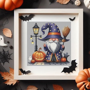 May include: A framed cross-stitch embroidery featuring a wizard gnome wearing a blue star-patterned hat and robe, holding a broomstick. The scene includes a tall black street lamp, a large jack-o'-lantern, a small ghost, and a black cat silhouette.