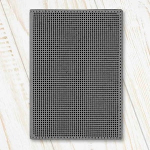 May include: A grey, rectangular, textured canvas with a grid pattern. The canvas is ideal for needlepoint or cross-stitch projects.
