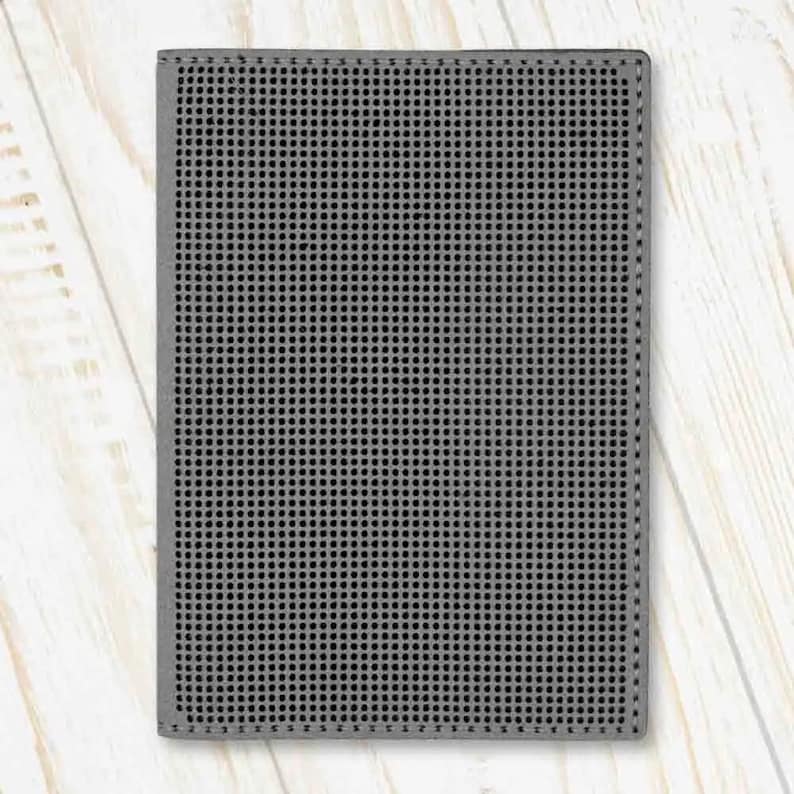 May include: A grey, rectangular, textured canvas with a grid pattern. The canvas is ideal for needlepoint or cross-stitch projects.