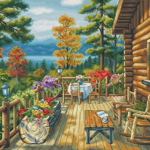 May include: A cross-stitch pattern depicts a cozy cabin porch overlooking a scenic landscape. The porch features a wooden table, chairs, and a flower box filled with colorful blooms. The background showcases a lake, trees, and a vibrant autumn color palette.