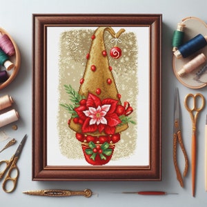 以下が含まれることがあります： 赤いポインセチアと金の帽子をかぶったクリスマスツリーのクロスステッチパターンが額装されています。ツリーは赤いベリーと赤いリボンで飾られています。