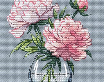 May include: Cross-stitch design of pink peonies in a clear glass vase. The flowers have multiple layers of petals and green leaves. The vase sits on a light blue background, creating a serene floral arrangement.