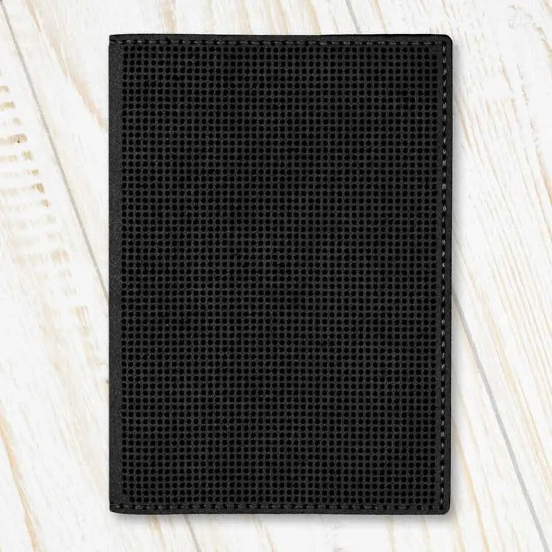 May include: Black leather wallet with a textured, grid-like pattern.