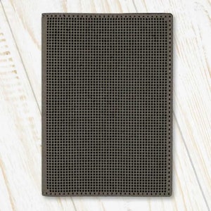 May include: A dark grey passport holder with a textured, grid-like pattern.