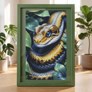 May include: A framed wall art print featuring a detailed illustration of a snake with golden-yellow and deep blue scales, large bright blue eyes, and a patterned head, surrounded by lush green foliage within a solid olive green wooden frame.