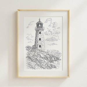 May include: Framed black and white cross-stitch art of a lighthouse on a rocky shore, under a cloudy sky. The artwork is in a light wood frame with a white mat. The lighthouse has a detailed design.