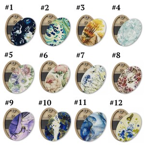 May include: Twelve heart-shaped wooden boxes with different patterned oval inserts. Each box has a number from 1 to 12 printed on the top.