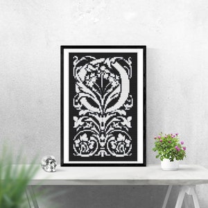 Könnte beinhalten: Schwarz-weiß gerahmter Druck eines dekorativen Buchstabens O mit floralen Designs.