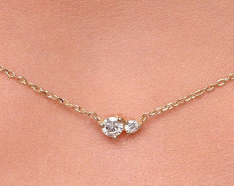 Puede incluir: Un delicado collar de cadena de oro con dos pequeños diamantes redondos.