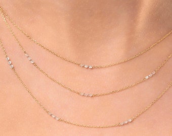 May include: A layered gold chain necklace with small diamonds set in each chain.