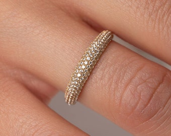 May include: A gold band ring with a pave setting of small diamonds.