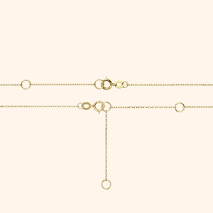 May include: A gold chain necklace with a lobster clasp and an adjustable length. The chain is made of small, linked circles.