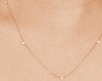 Puede incluir: Un delicado collar de oro con cinco pequeños diamantes espaciados uniformemente a lo largo de la cadena.