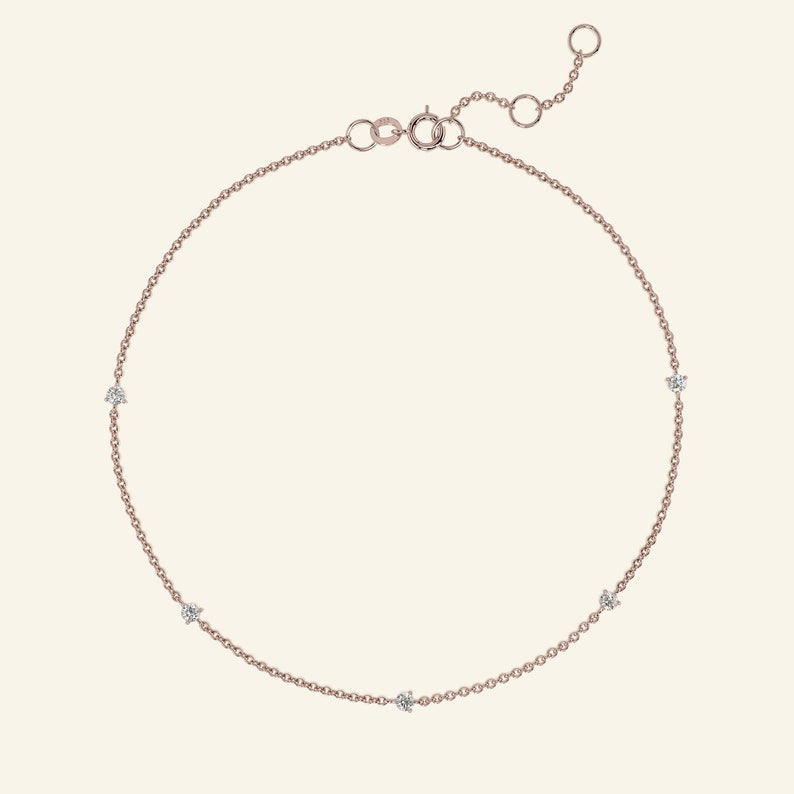 May include: A delicate rose gold chain anklet with five small sparkling diamonds.