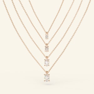May include: Four gold chain necklaces with oval-shaped diamond pendants of varying sizes.