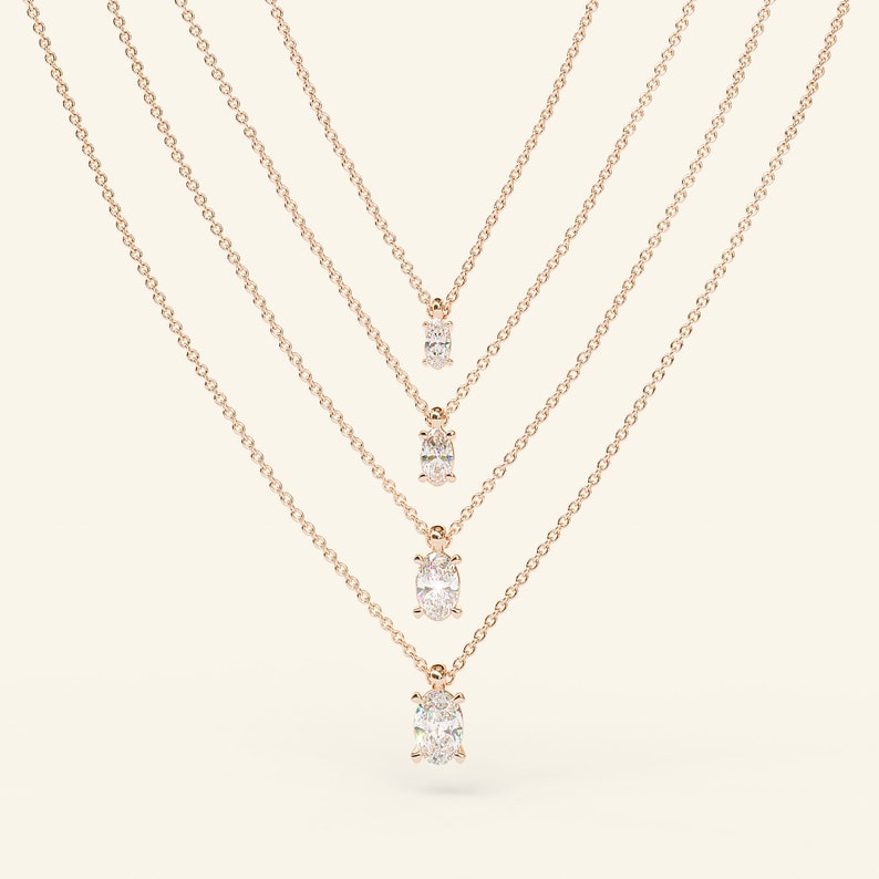 May include: Four gold chain necklaces with oval-shaped diamond pendants of varying sizes.