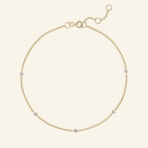 May include: A delicate gold chain bracelet with five small diamonds.